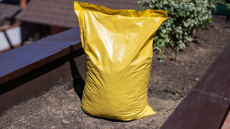 A yellow soil bag atop a garden bed
