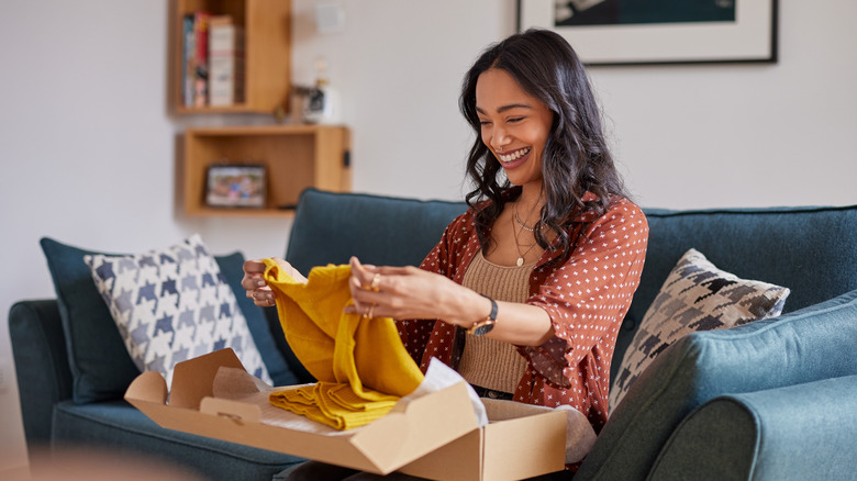 woman happily unboxing some clothing