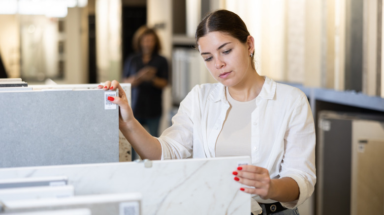Woman in a store browsing material samples for a bathroom