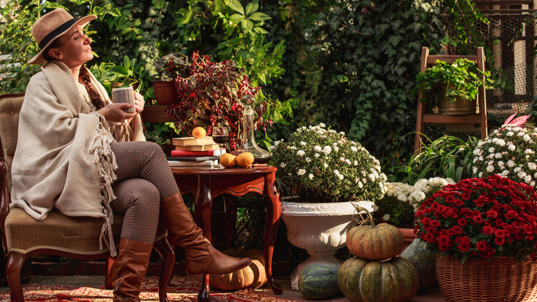 A woman is relaxing outside in a shady fall garden