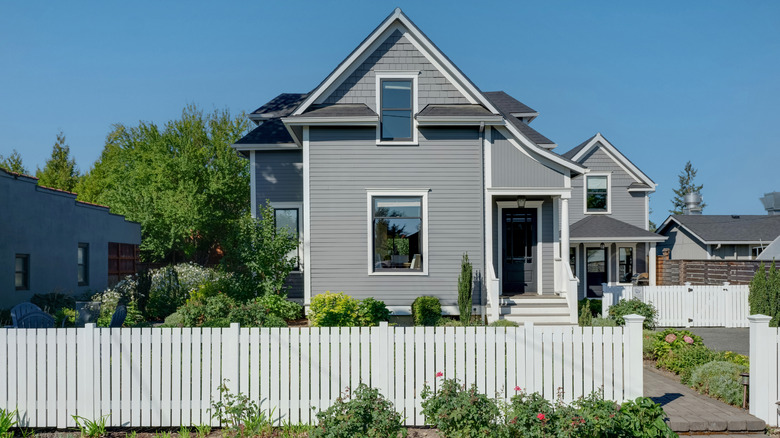 A beautiful two-story house with a white fence in front of it
