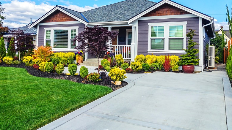Eggplant-color home with stone steps and a concrete driveway