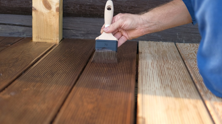 Person applying stain to wood