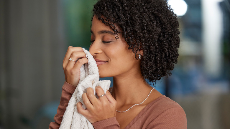 Woman smelling a fresh article of clothing