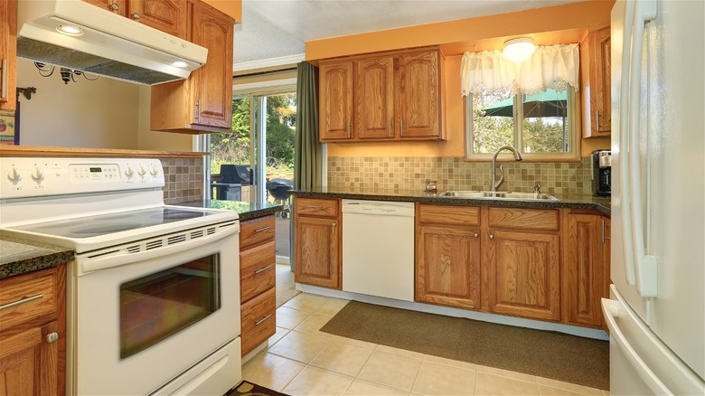 Kitchen with white appliances and honey oak cabinets.