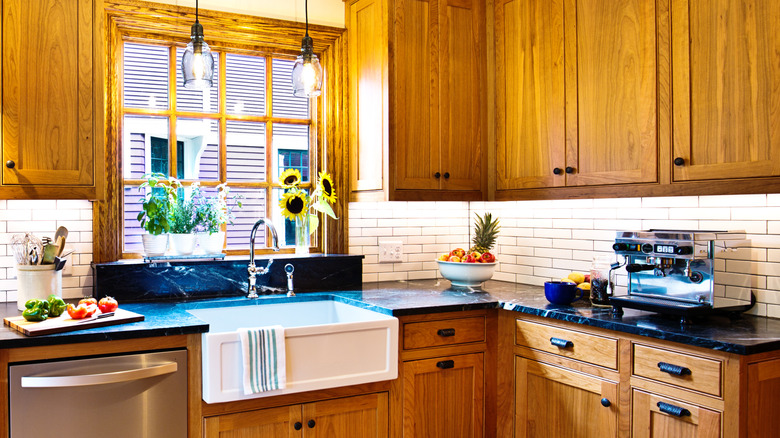 Honey oak kitchen cabinets updated with black hardware