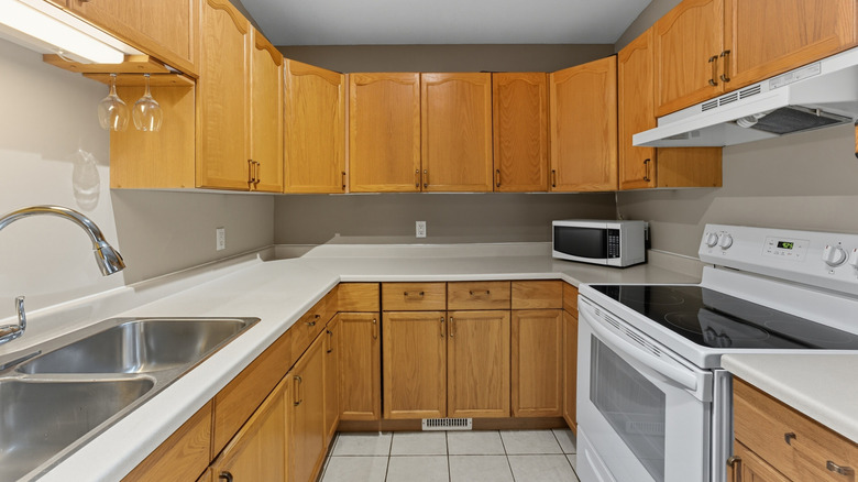 Kitchen with honey oak cabinets and white appliances.