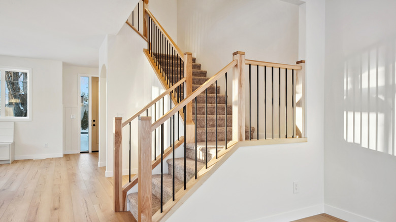 A home with a staircase featuring a plain white staircase landing