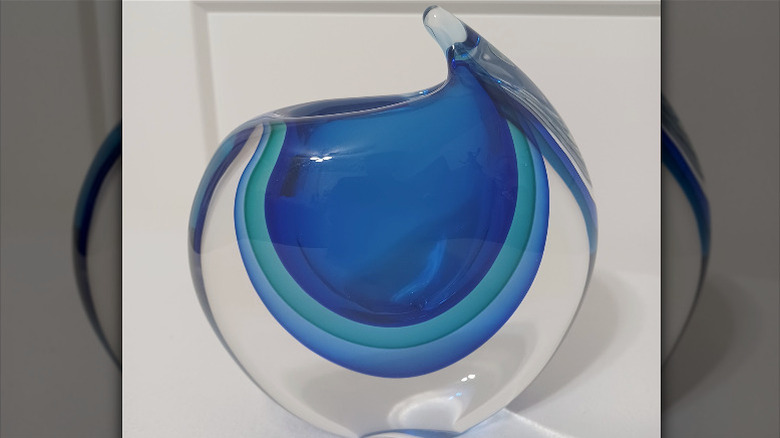 A round sommerso glass vase featuring three shades of blue encased in clear glass