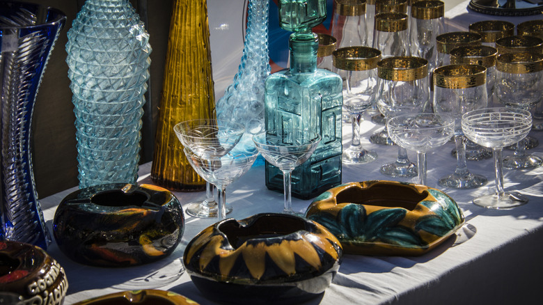 Assorted vintage glassware displayed on a sale table