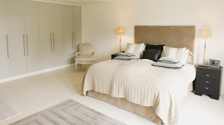 Stylish bedroom with bedskirt on made bed