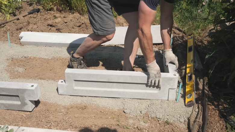 Cast concrete garden panels are assembled into a raised bed planter box