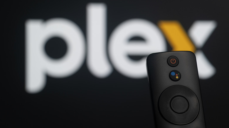 A slightly blurry image of the Plex logo on a TV with a remote