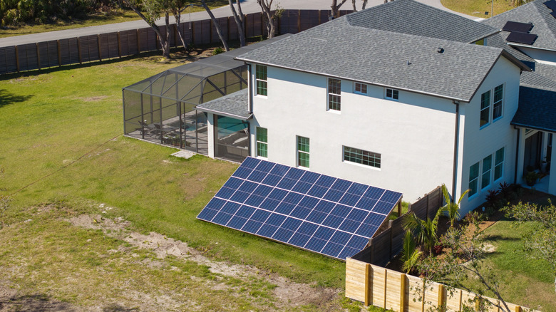 Solar photovoltaic panels mounted on backyard ground of a home