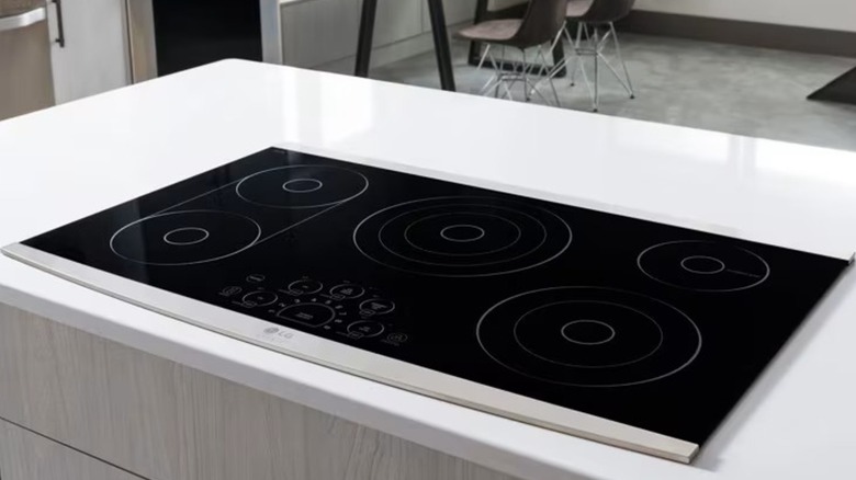 An electric LG cooktop is installed on a white countertop in a kitchen.