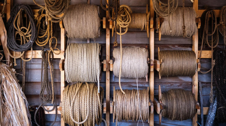 Rolls of different kinds of rope hanging on a wall in a garage or barn