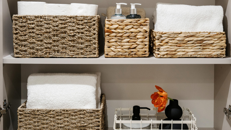 Shelves in a bathroom linen closet with baskets.