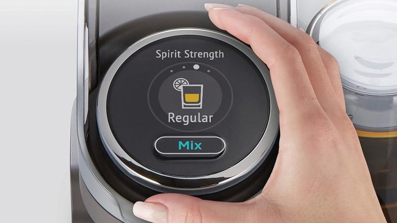 Hand adjusting the strength of a mixed drink on a cocktail machine