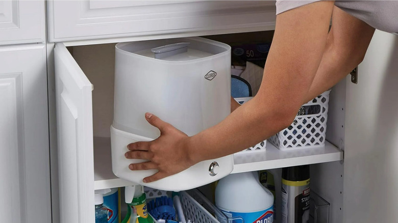 Person take a small steam sanitizer out of the cupboard