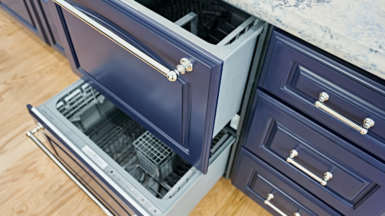 Double drawer dishwasher in a kitchen with navy blue cabinets with silver drawer pulls