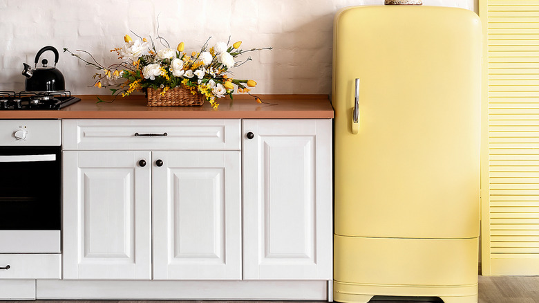 A sleek kitchen with a yellow refrigerator.