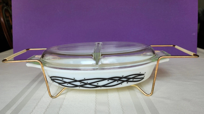 The Pyrex oval divided dish in barbed wire sitting in a metal cradle