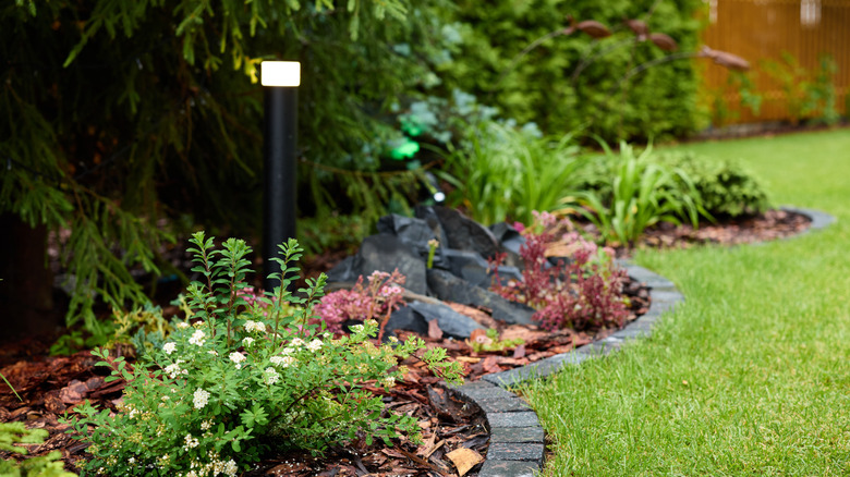 Gray stone edging around mulched garden beds