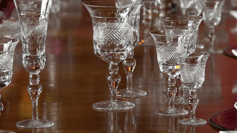 Closeup of various Cumbria Crystal glassware in the Grasmere pattern on a wooden table