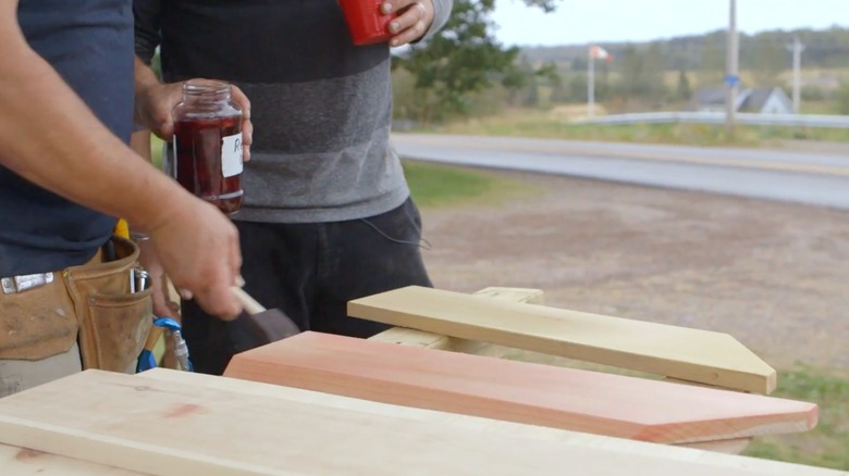 Person adding red onion stain to wood