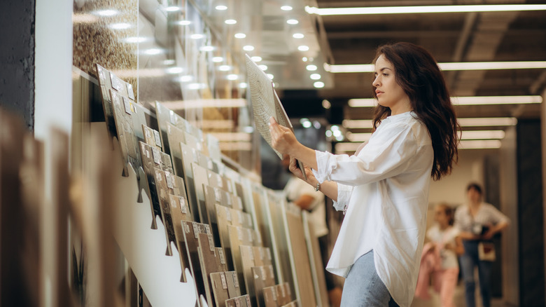 A woman compares too tile choices while shopping.