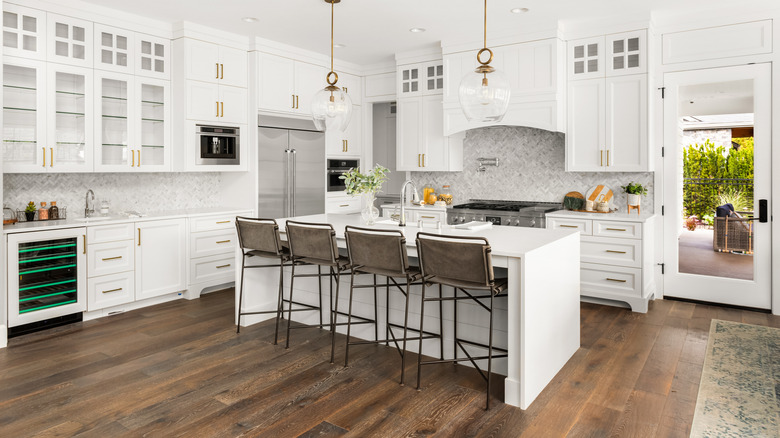 Stylish white kitchen with four bar chairs