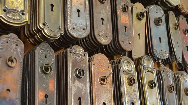 Antique doorknob plates with keyholes hanging on pegs