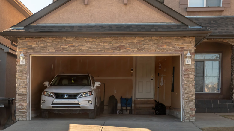 a garage with a car parked inside and room for storage
