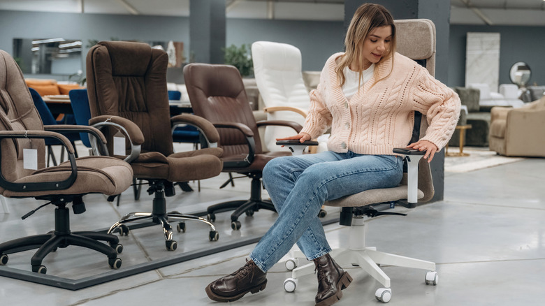 A woman testing out an office chair in a furniture store