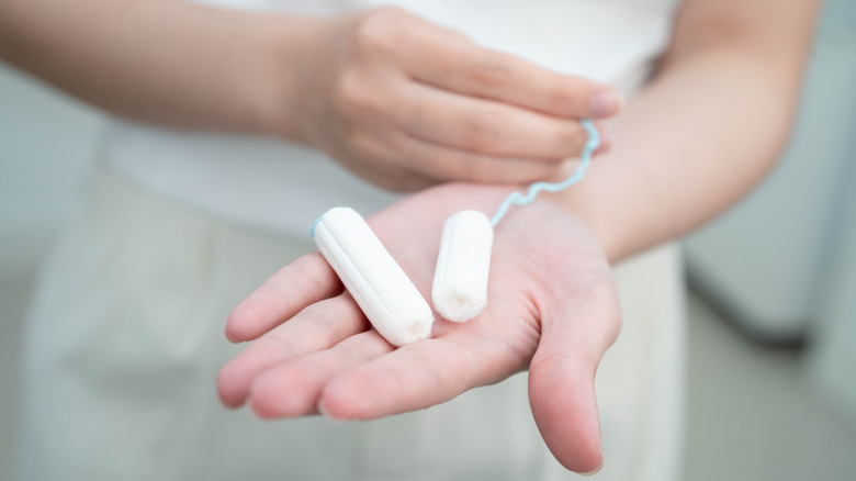 A woman holding cotton tampons without applicators.