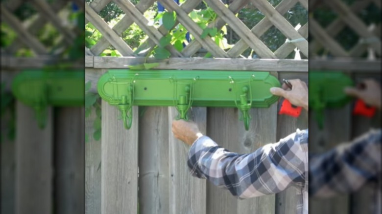 Person mounting a DIY planter on a fence