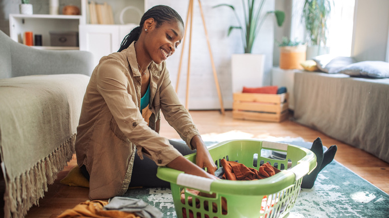 Woman sitting on floor folding laundry