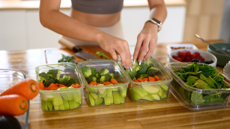 Woman placing food in glass storage containers