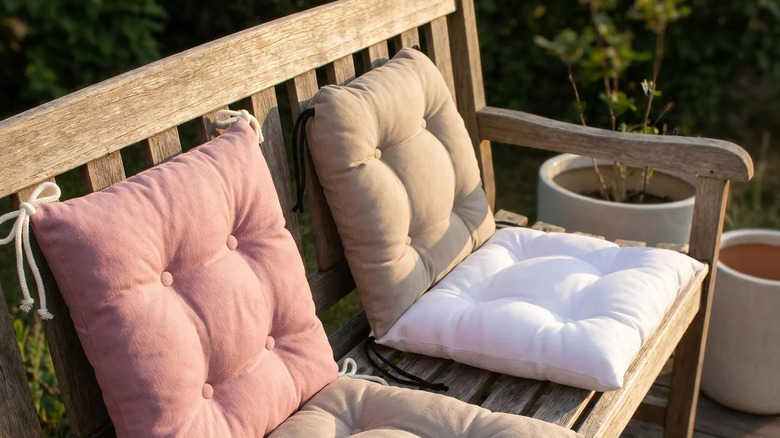 Wooden bench outdoors with linen cushions