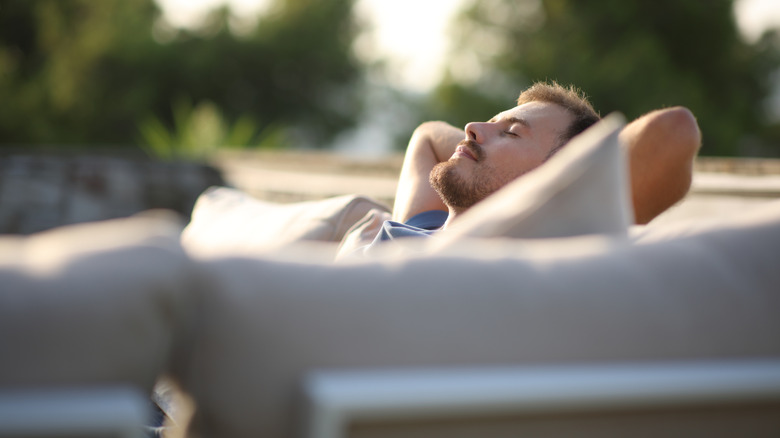 man relaxing on outdoor furniture