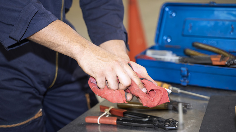 A person wipes down their tools after using them.
