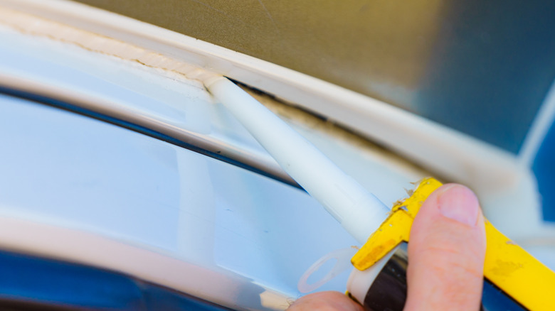 Person using caulk to seal a gap