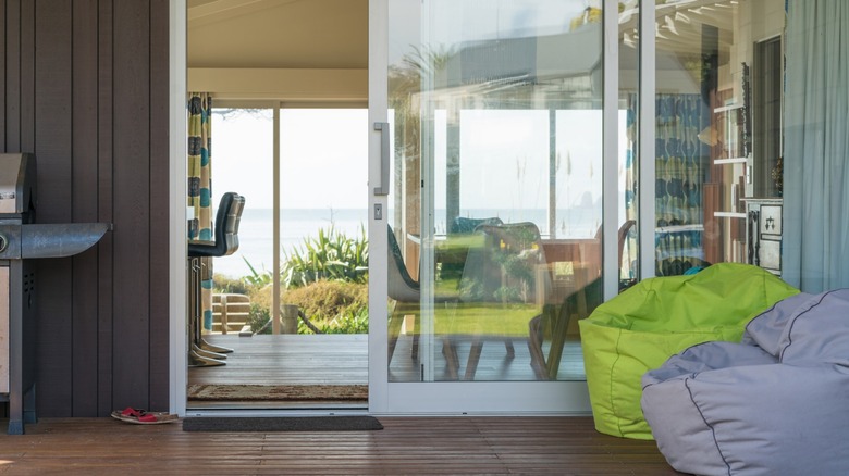 A room with sliding glass doors and bean bag chairs in the foreground