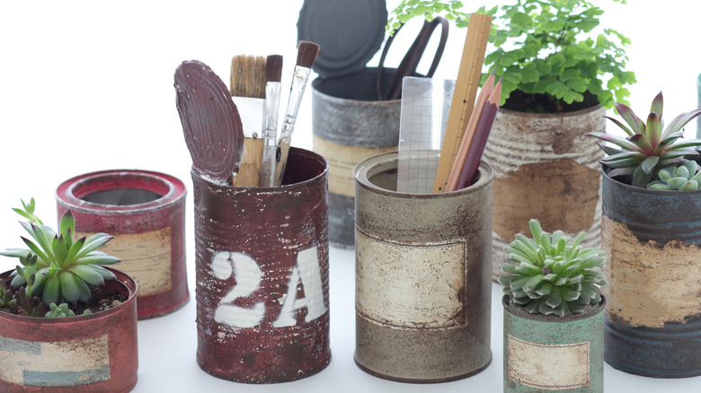A collection of rustic-looking tin cans used for plants and storage