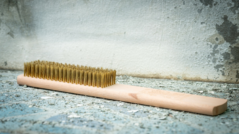 Brass bristle brush on top of distressed concrete