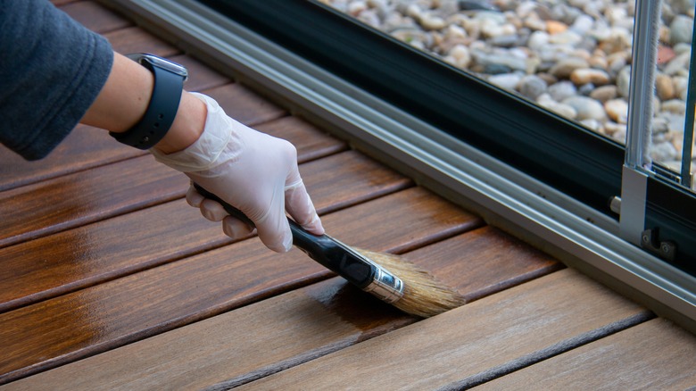 person staining a deck