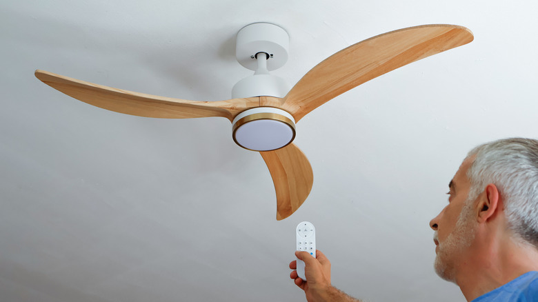 Man turning on a modern wooden fan