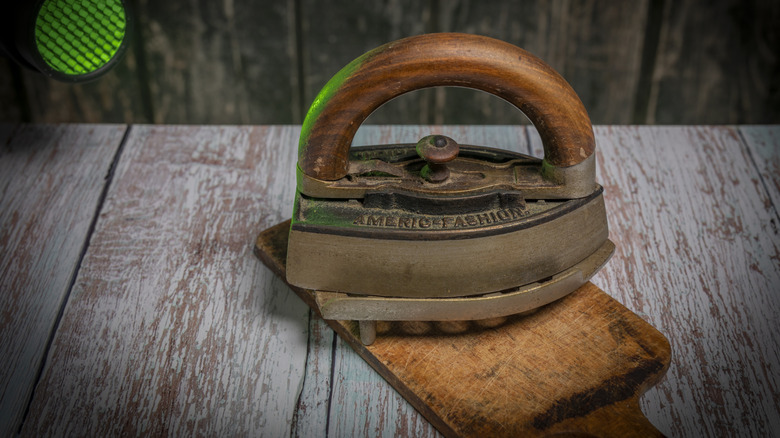 An old-school box iron on a wooden surface