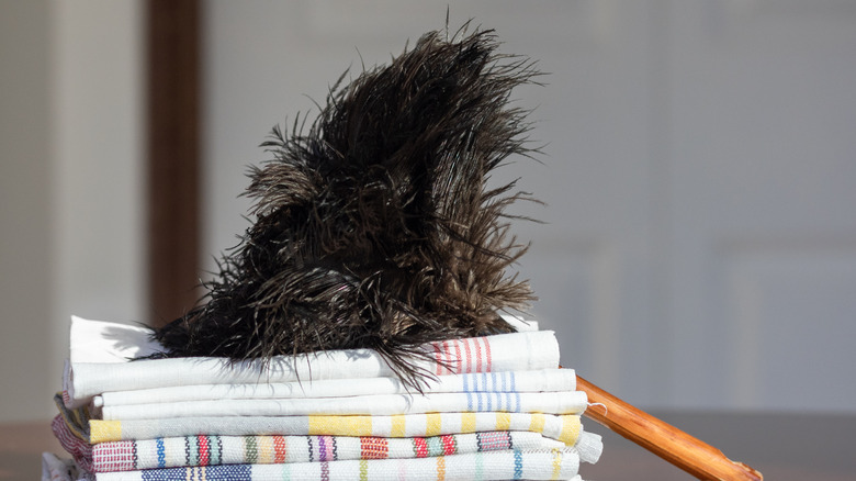 An old-school ostrich feather duster leaning on a pile of towels