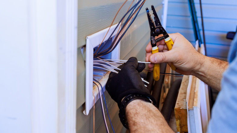 Electrician working electrical wires in a home